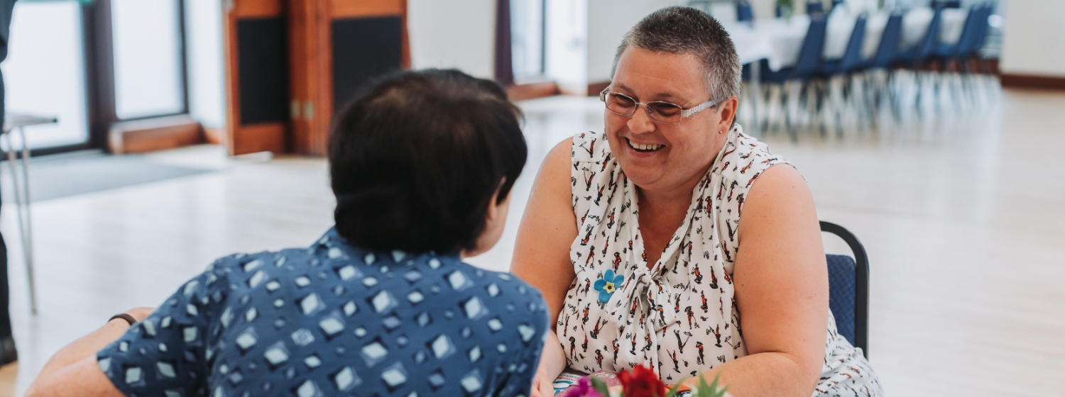 Two friendly women chatting over a table